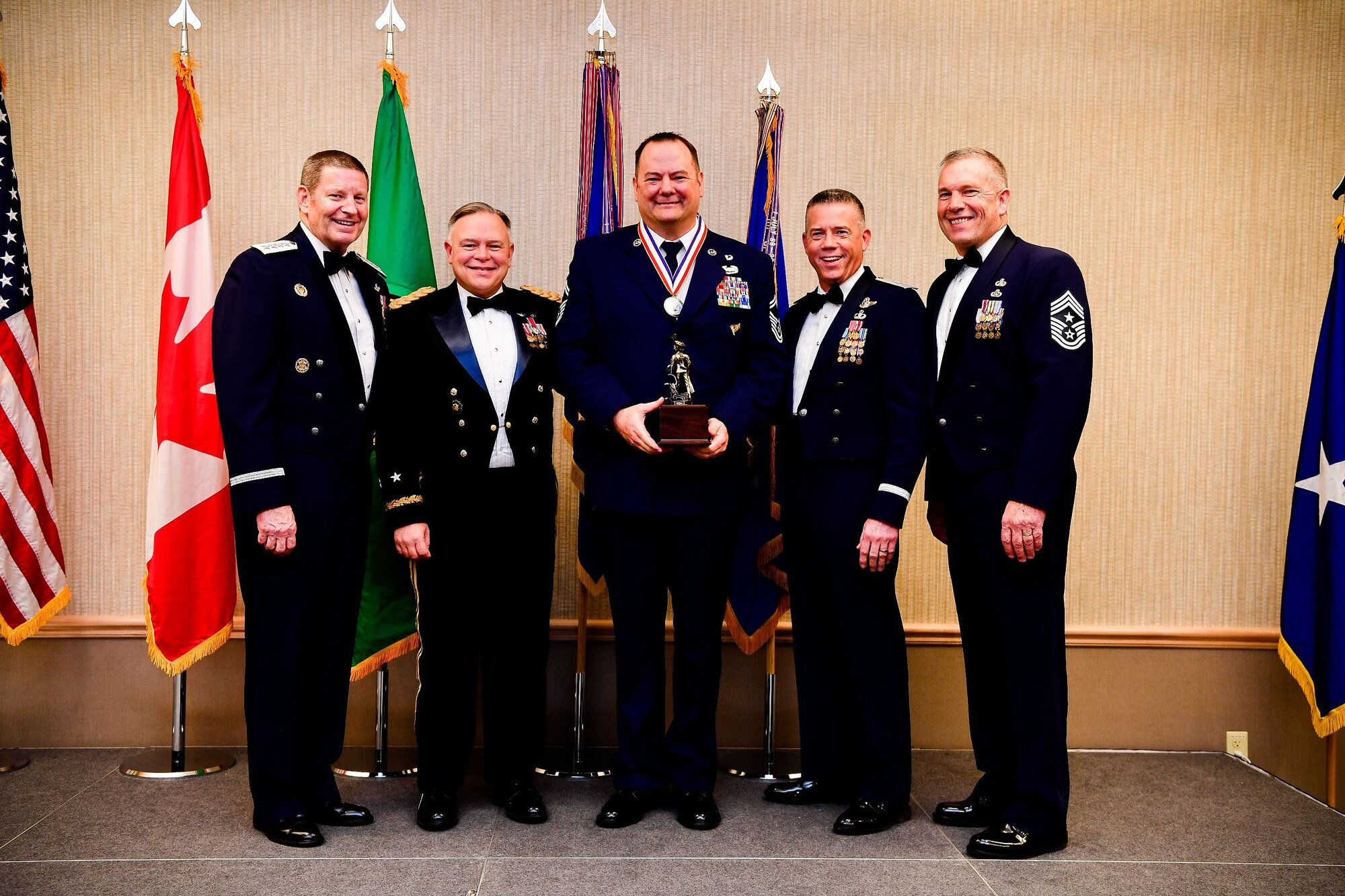 Senior Master Sgt. Jason Roland, the operations superintendent for the 111th Air Support Operations Squadron, 141st Air Refueling Wing, is presented with the Senior Non-Commissioned Officer of the Year trophy at the Washington Air National Guard’s 9th Annual Awards Banquet held at the American Lake Conference Center on Joint Base Lewis-McChord, Washington, Jan. 27, 2018.  Roland was awarded the trophy for his outstanding contributions to the Washington Air National Guard over the last year.  Pictured from left to right are: Gen. Robin Rand, Air Force Global Strike Command and Air Forces Strategic-Air, U.S. Strategic Command commander; Maj. Gen. Bret Daugherty, Adjutant General of the Washington National Guard, Roland, Brig. Gen. Jeremy Horn, commander of the Washington Air National Guard, and Chief Master Sgt. Max Tidwell, WA ANG command chief. (U.S. Air National Guard photo by Tech. Sgt. Timothy Chacon)