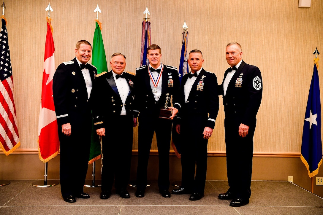 Capt. Nathan Carlson, an operations flight commander with the 116th Air Support Operations Squadron, 194th Wing, is presented with the Company Grade Officer of the Year trophy at the Washington Air National Guard’s 9th Annual Awards Banquet held at the American Lake Conference Center on Joint Base Lewis-McChord, Washington, Jan. 27, 2018.  Carlson was awarded the trophy for his outstanding contributions to the Washington Air National Guard over the last year.  Pictured from left to right are: Gen. Robin Rand, Air Force Global Strike Command and Air Forces Strategic-Air, U.S. Strategic Command commander; Maj. Gen. Bret Daugherty, Adjutant General of the Washington National Guard, Carlson, Brig. Gen. Jeremy Horn, commander of the Washington Air National Guard, and Chief Master Sgt. Max Tidwell, WA ANG command chief. (U.S. Air National Guard photo by Tech. Sgt. Timothy Chacon)