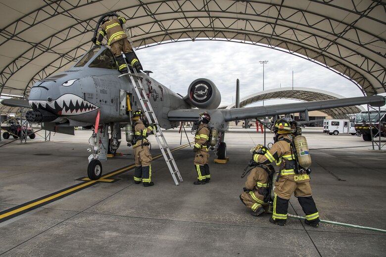 Firefighters from the 23d Civil Engineer Squadron (CES), perform rescue operations, Jan. 24, 2018, at Moody Air Force Base, Ga. Firefighters from the 23d CES conducted A-10C Thunderbolt II extraction training to practice extinguishing an aircraft fire and quickly rescuing a pilot from an A-10. The 23d CES holds the extraction training twice annually and are evaluated on the amount of time it takes them to rescue a pilot from the cockpit. (U.S. Air Force photo by Airman Eugene Oliver)