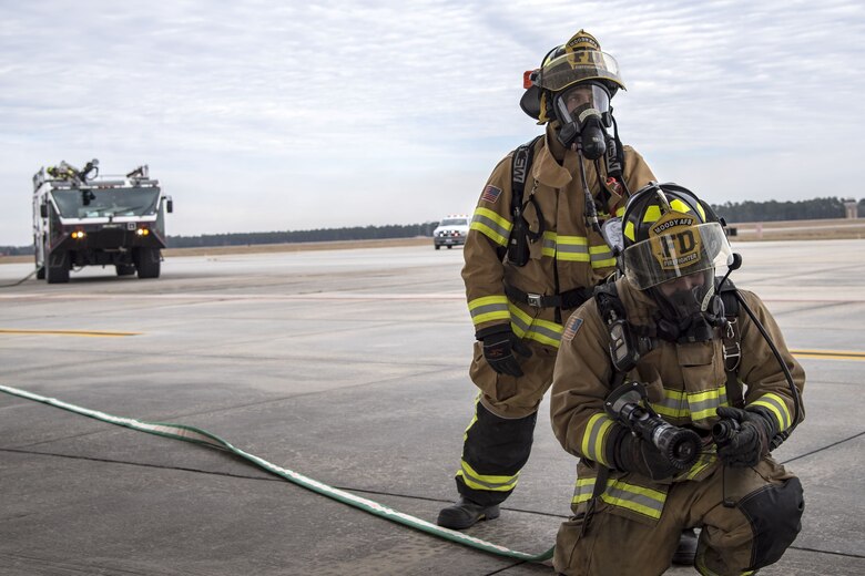 Firefighters from the 23d Civil Engineer Squadron (CES), prepare to shoot water out of a hose, Jan. 24, 2018, at Moody Air Force Base, Ga. Firefighters from the 23d CES conducted A-10C Thunderbolt II extraction training to practice extinguishing an aircraft fire and quickly rescuing a pilot from an A-10. The 23d CES holds the extraction training twice annually and are evaluated on the amount of time it takes them to rescue a pilot from the cockpit. (U.S. Air Force photo by Airman Eugene Oliver)