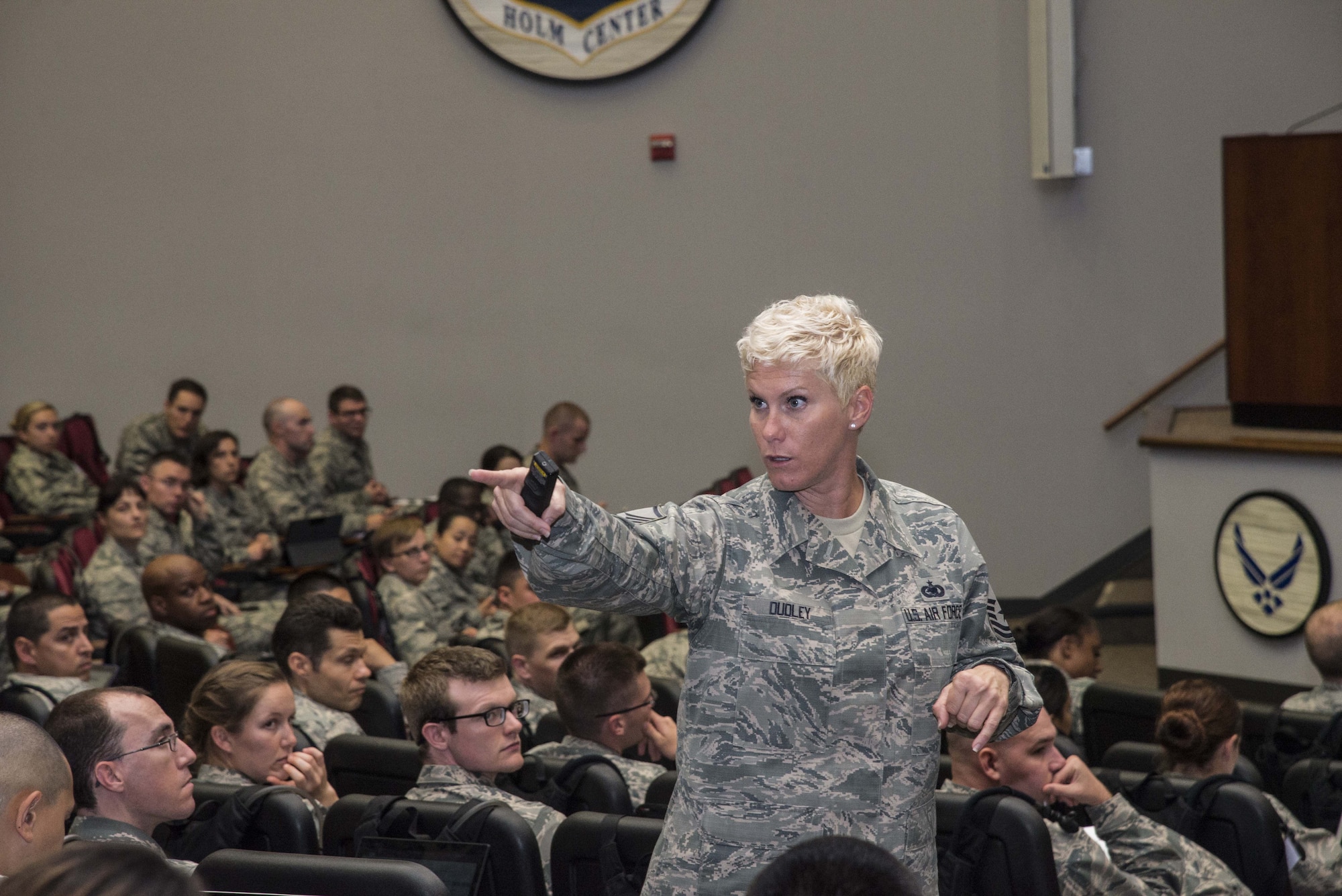Master Sgt. Tiffany Dudley, Officer Training School military training instructor, teaches a class of approximately 100 OTS students, June 7, 2017, at Maxwell Air Force Base, Ala. During this classroom instruction, Dudley taught the students the proper wear of all combinations of the Air Force blues uniform. (U.S. Air Force photo by Senior Airman Alexa Culbert)