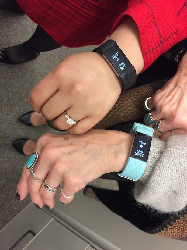 People wearing fitness trackers on their wrists.