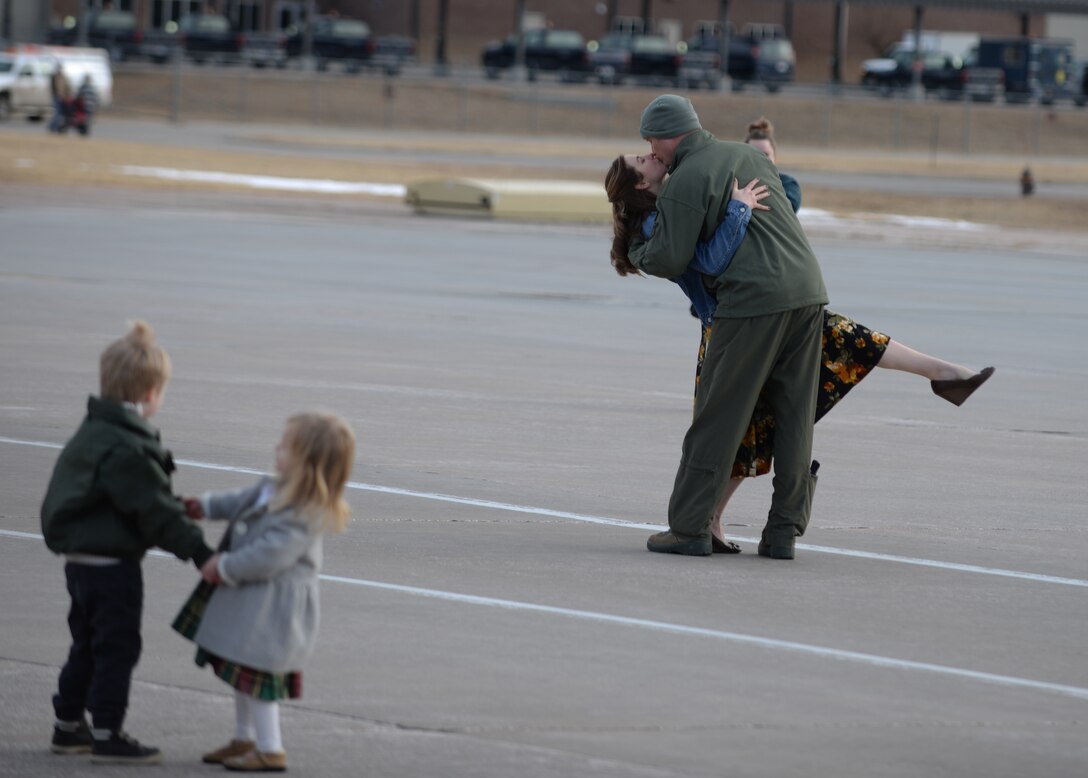 Maj. Jeremey, a pilot assigned to the 37th Bomb Squadron, kisses his wife on the flight line at Ellsworth Air Force Base, S.D., after returning from a six-month deployment to Andersen AFB, Guam, Jan. 25, 2018. B-1 bomber aircrews conducted sorties close to South Korea’s northern border as part of the U.S. Pacific Command’s Continuous Bomber Presence mission. (U.S. Air Force photo by Airman 1st Class Thomas Karol)