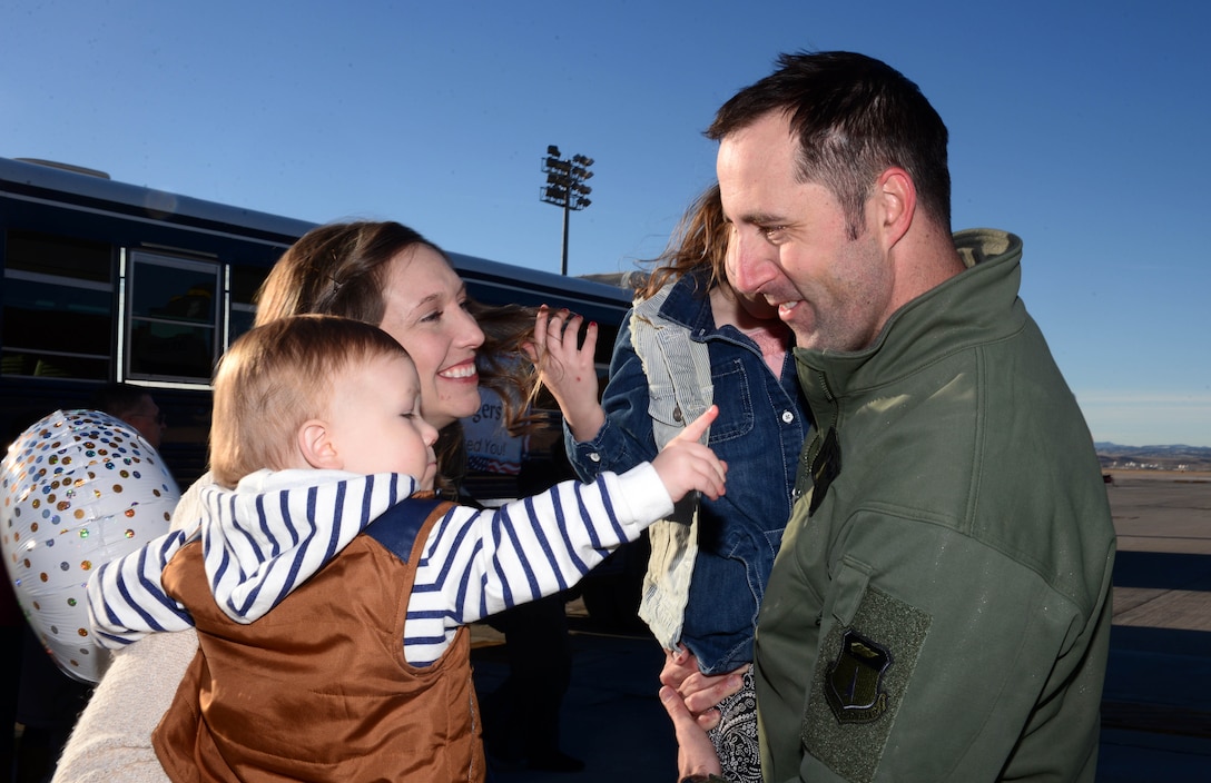 Capt. Lance, a weapons system officer assigned to the 37th Bomb Squadron, sees his family for the first time in over six months during a redeployment at Ellsworth Air Force Base, S.D., Jan. 24, 2018. B-1 bomber aircrews conducted sorties close to South Korea’s norther border as part of the U.S. Pacific Command’s Continuous Bomber Presence mission. (U.S. Air Force photo by Airman 1st Class Donald Knechtel)