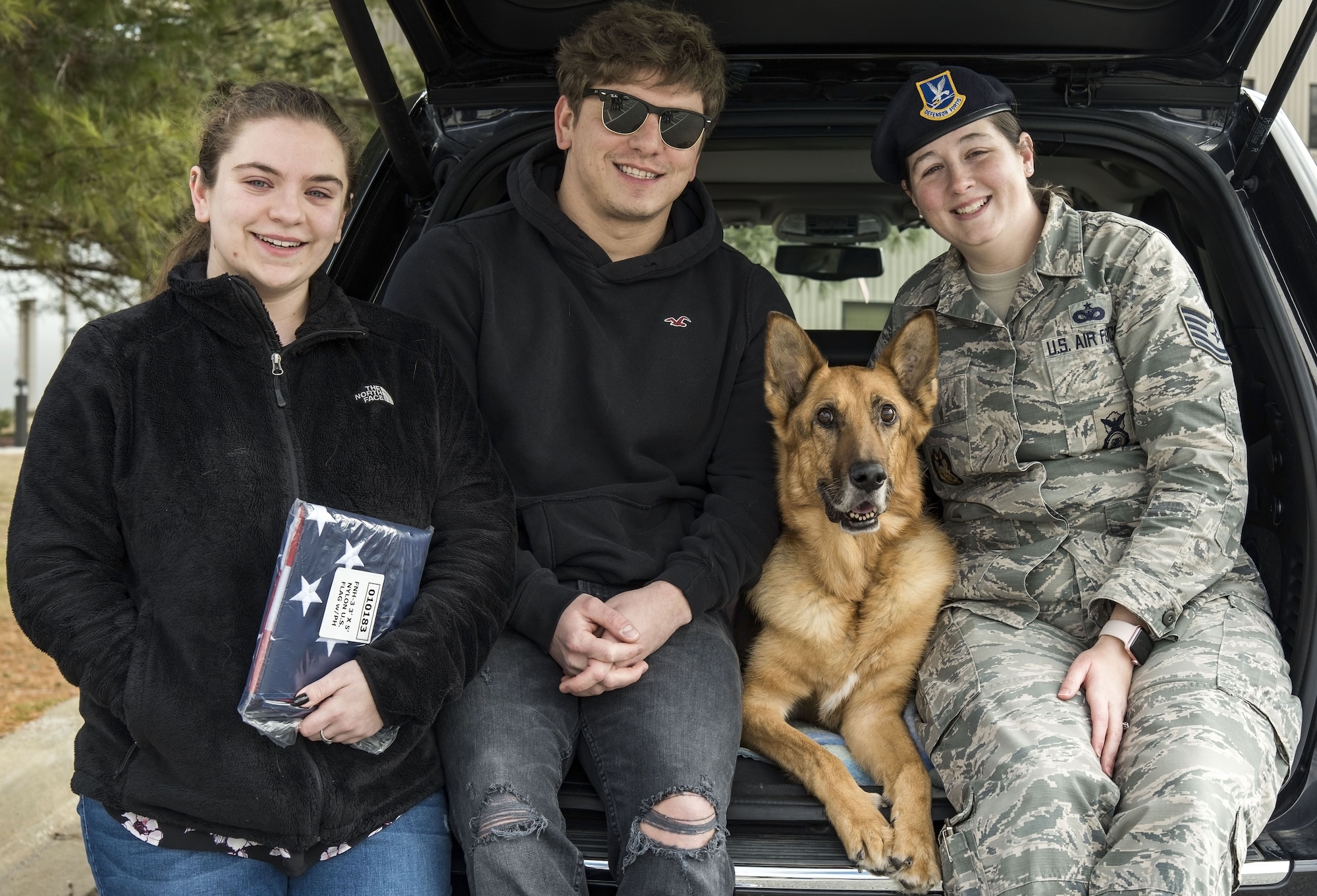 Mya Spangenberg along with her father, retired Tech. Sgt. Jason Spangenberg; Tech. Sgt. Rachel Weis, 436th Airlift Wing inspector general inspections NCO in charge; and retired Military Working Dog Rico pose for a photo Jan. 24, 2018, at the Veterinary Treatment Facility on Dover Air Force Base, Del. MWD Rico was humanely euthanized shortly after being carried into the facility by Spangenberg, his owner. (U.S. Air Force photo by Roland Balik)