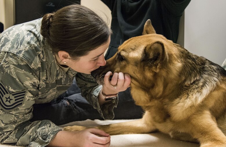 Tech. Sgt. Rachel Weis, 436th Airlift Wing inspector general inspections NCO in charge, gives retired Military Working Dog Rico a kiss on his snout Jan. 24, 2018, at the Veterinary Treatment Facility on Dover Air Force Base, Del. MWD Rico was diagnosed with Canine Degenerative Myelopathy, which led to his retirement back in January 2016. (U.S. Air Force photo by Roland Balik)