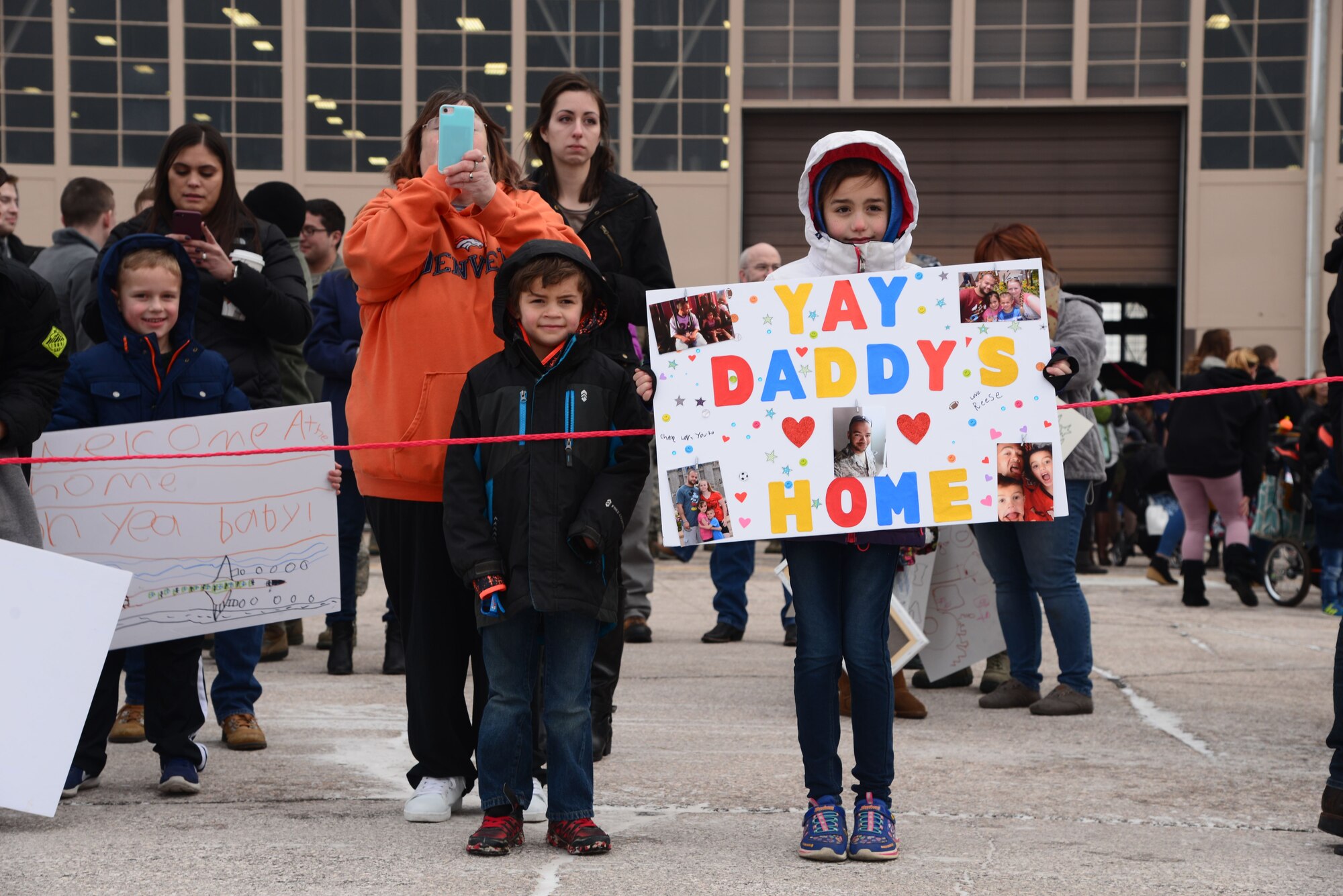 Family members wait for their Airmen on the flight line at Ellsworth Air Force Base, S.D., Jan. 29, 2018. B-1 bombers from the 37th Bomb Squadron and Airmen from the 37th Aircraft Maintenance Unit returned from a six-month deployment to Andersen AFB, Guam, where they took part in the Continuous Bomber Presence mission. (U.S. Air Force photo by Airman 1st Class Donald Knechtel)