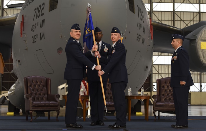 Col. Mark Harris, left, 437th Maintenance Group commander, passes the guideon to Maj. David Rhodes, right, 437th Maintenance Squadron incoming commander, during a change of command ceremony at Joint Base Charleston, S.C., Jan. 26, 2018. Rhodes assumed command of the squadron following the outgoing commander Lt. Col. Michael Coppola.