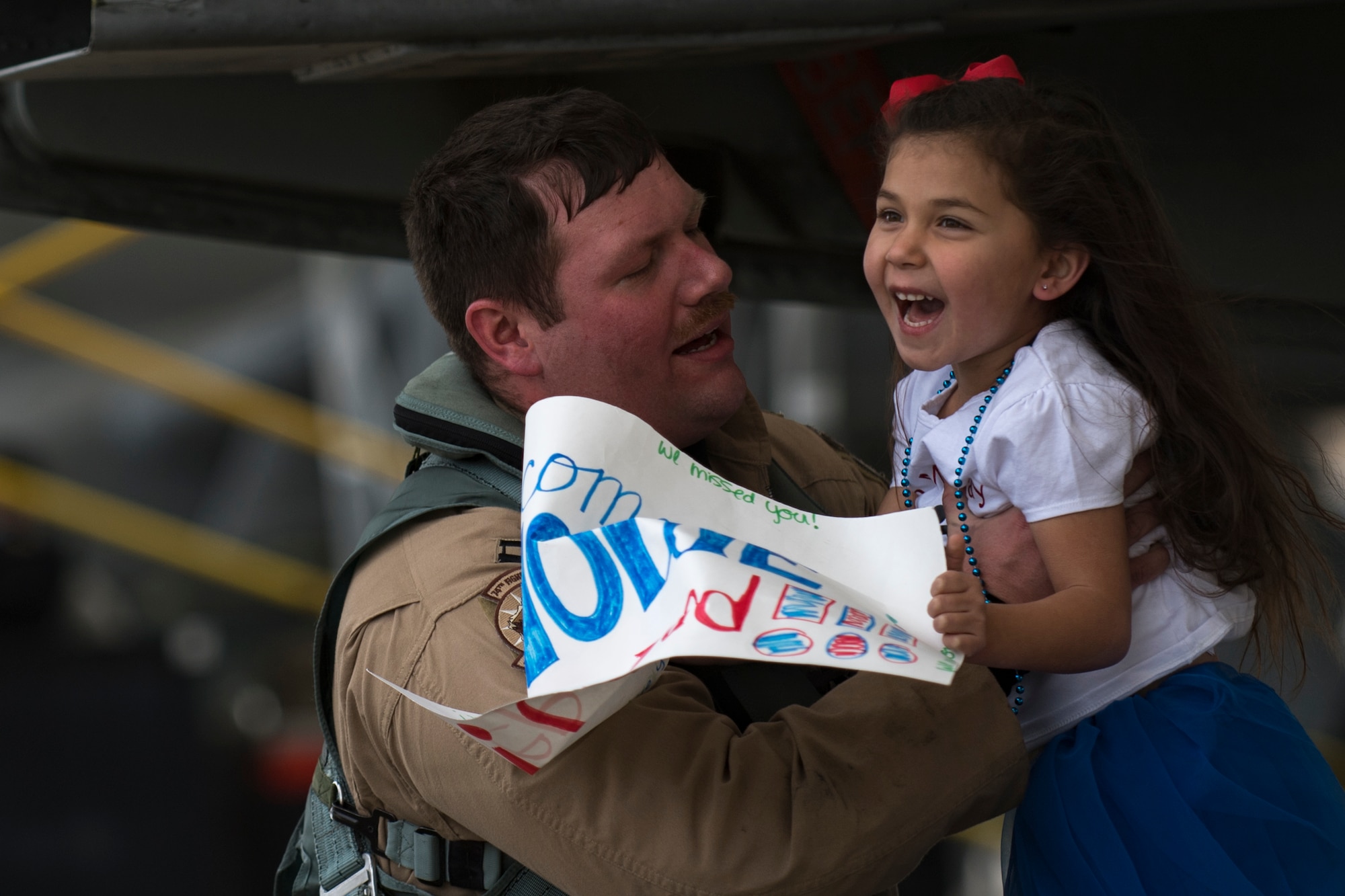 Capt. Brendan Lanphear, 74th Fighter Squadron pilot, lifts his daughter Rownin after returning from a deployment, Jan. 26, 2018, at Moody Air Force Base, Ga. During the seven-month deployment, the 74th FS flew more than 1,700 sorties, employed weapons more than 4,400 times, destroyed 2,300 targets and killed 2,800 ISIS insurgents. (U.S. Air Force photo by Senior Airman Daniel Snider)