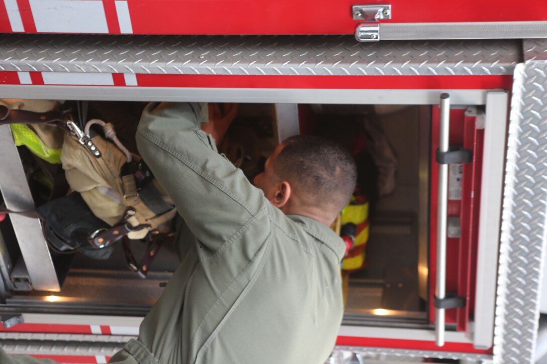 Sgt. Ayham Johnson, an aircraft rescue and firefighting Marine stationed at Marine Corps Air Station Miramar, looks over firefighting equipment in a San Diego Fire Department truck in San Diego, Jan. 25. Interactions between military and civillian firefighters gives both parties an opportunity to learn from each other and build relationships that could assist in emergency situations. (Marine Corps photo by Cpl. Daniel Auvert/Released)