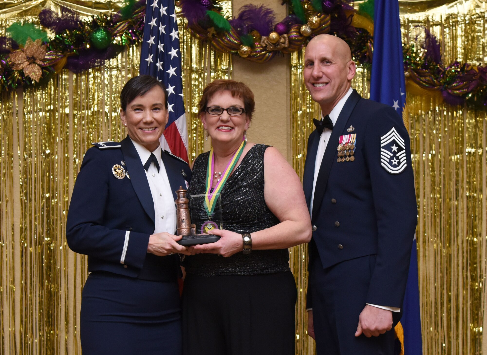 Col. Debra Lovette, 81st Training Wing commander, and Chief Master Sgt. Kenneth Carter, 81st TRW command chief, present Kerry Hudson, 81st Diagnostic and Therapeutics Squadron diagnostic radiology technologist, with the Civilian Non-Supervisory Category II Annual Award during the 2017 Keesler Annual Awards Ceremony at the Bay Breeze Event Center Jan. 25, 2018, on Keesler Air Force Base, Mississippi. During the ceremony base leadership recognized outstanding Airmen and civilians from across the installation for their accomplishments throughout 2017. (U.S. Air Force photo by Kemberly Groue)