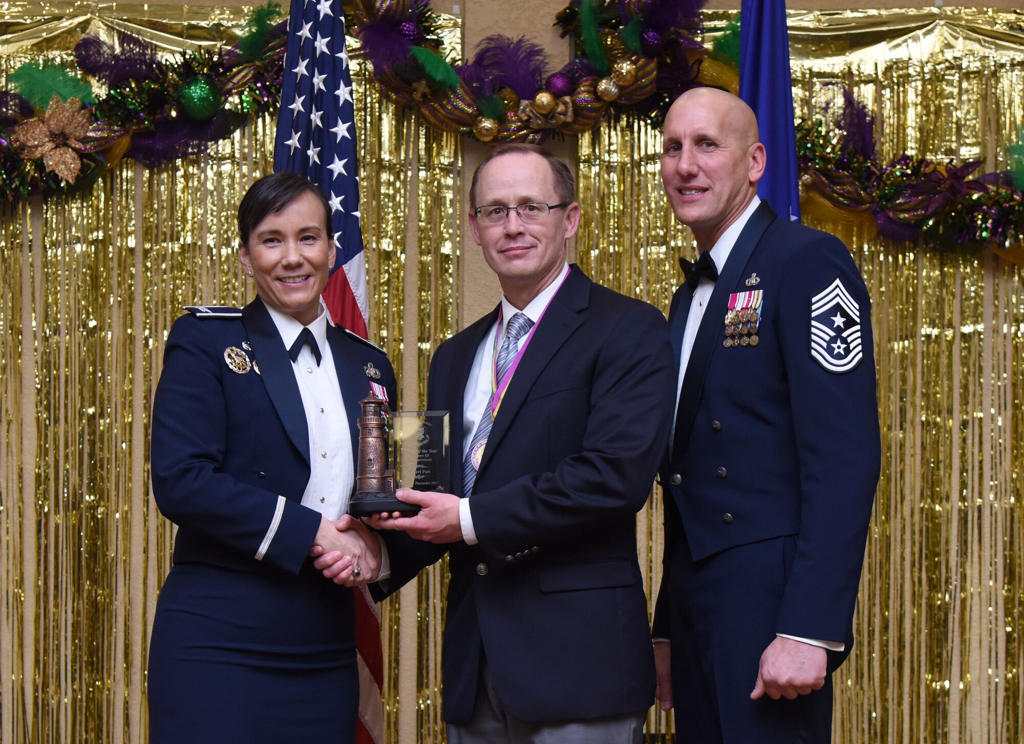 Col. Debra Lovette, 81st Training Wing commander, and Chief Master Sgt. Kenneth Carter, 81st TRW command chief, present Robert Patt, 333rd Training Squadron undergraduate cyberspace training manager, with the Civilian Non-Supervisory Category III Annual Award during the 2017 Keesler Annual Awards Ceremony at the Bay Breeze Event Center Jan. 25, 2018, on Keesler Air Force Base, Mississippi. During the ceremony base leadership recognized outstanding Airmen and civilians from across the installation for their accomplishments throughout 2017. (U.S. Air Force photo by Kemberly Groue)