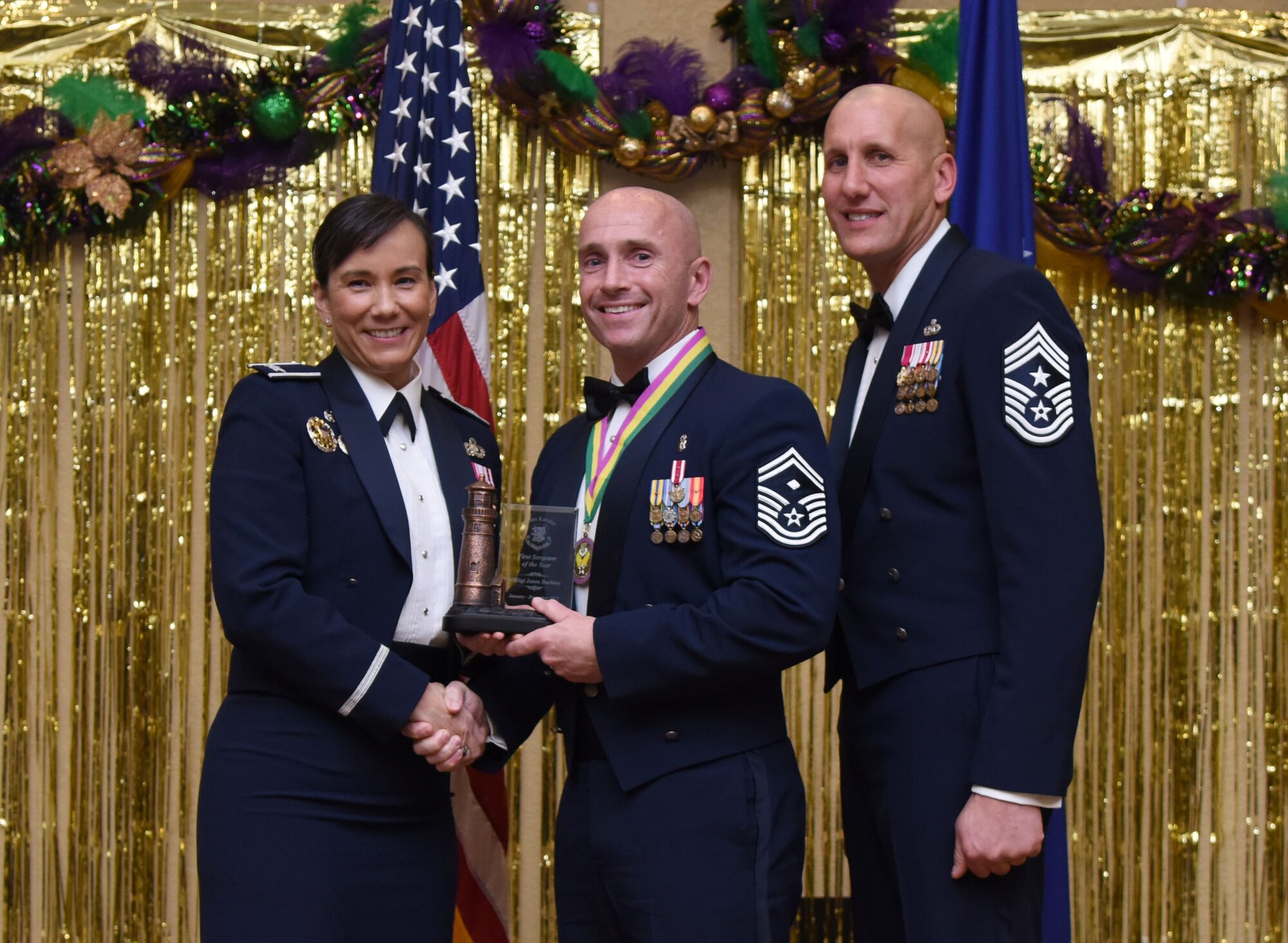 Col. Debra Lovette, 81st Training Wing commander, and Chief Master Sgt. Kenneth Carter, 81st TRW command chief, present Senior Master Sgt. Jason Buckley, 81st Medical Operations Squadron first sergeant, with the First Sergeant Annual Award during the 2017 Keesler Annual Awards Ceremony at the Bay Breeze Event Center Jan. 25, 2018, on Keesler Air Force Base, Mississippi. During the ceremony base leadership recognized outstanding Airmen and civilians from across the installation for their accomplishments throughout 2017. (U.S. Air Force photo by Kemberly Groue)