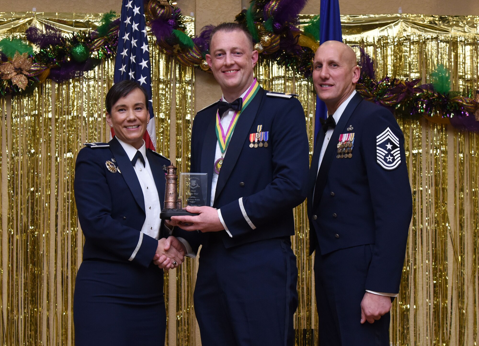 Col. Debra Lovette, 81st Training Wing commander, and Chief Master Sgt. Kenneth Carter, 81st TRW command chief, present Maj. Cory Hedin, 81st Diagnostic and Therapeutics Squadron pharmacy support chief, with the Field Grade Officer Annual Award during the 2017 Keesler Annual Awards Ceremony at the Bay Breeze Event Center Jan. 25, 2018, on Keesler Air Force Base, Mississippi. During the ceremony base leadership recognized outstanding Airmen and civilians from across the installation for their accomplishments throughout 2017. (U.S. Air Force photo by Kemberly Groue)