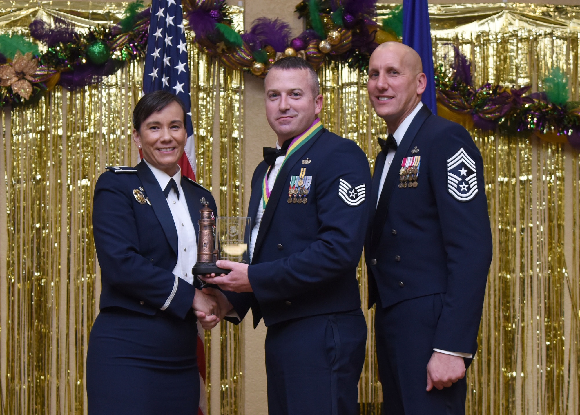 Col. Debra Lovette, 81st Training Wing commander, and Chief Master Sgt. Kenneth Carter, 81st TRW command chief, present Tech. Sgt. Jason Bernich, 81st Force Support Squadron honor guard NCO in charge, with the Honor Guard Manager of the Year Annual Award during the 2017 Keesler Annual Awards Ceremony at the Bay Breeze Event Center Jan. 25, 2018, on Keesler Air Force Base, Mississippi. During the ceremony base leadership recognized outstanding Airmen and civilians from across the installation for their accomplishments throughout 2017. (U.S. Air Force photo by Kemberly Groue)