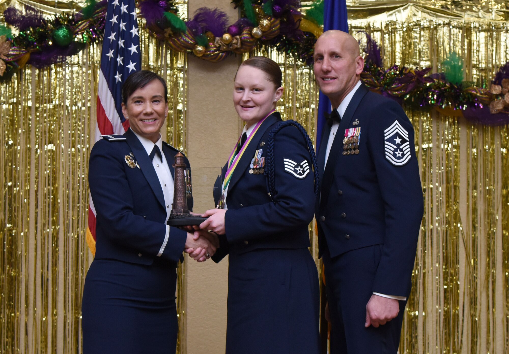 Col. Debra Lovette, 81st Training Wing commander, and Chief Master Sgt. Kenneth Carter, 81st TRW command chief, present Staff Sgt. Lauren Harris, 338th Training Squadron military training leader, with the Junior NCO Military Training Leader of the Year Annual Award during the 2017 Keesler Annual Awards Ceremony at the Bay Breeze Event Center Jan. 25, 2018, on Keesler Air Force Base, Mississippi. During the ceremony base leadership recognized outstanding Airmen and civilians from across the installation for their accomplishments throughout 2017. (U.S. Air Force photo by Kemberly Groue)
