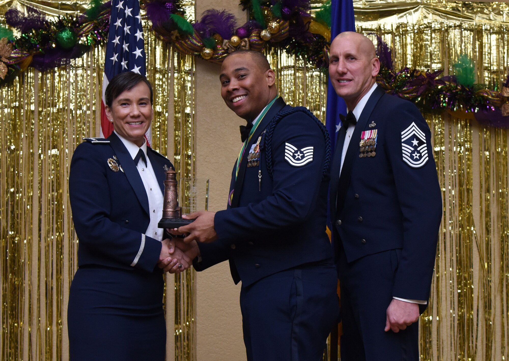 Col. Debra Lovette, 81st Training Wing commander, and Chief Master Sgt. Kenneth Carter, 81st TRW command chief, present Tech. Sgt. Jonathan McElroy, 338th Training Squadron military training leader, with the Volunteer of the Year Annual Award during the 2017 Keesler Annual Awards Ceremony at the Bay Breeze Event Center Jan. 25, 2018, on Keesler Air Force Base, Mississippi. During the ceremony base leadership recognized outstanding Airmen and civilians from across the installation for their accomplishments throughout 2017. (U.S. Air Force photo by Kemberly Groue)
