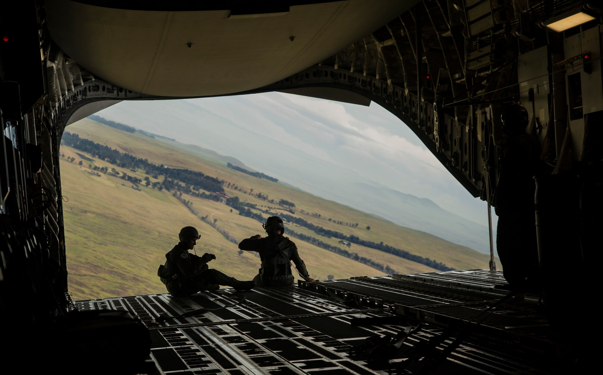 Members of the flight crew monitor a cargo pallet during an airdrop mission over Big Island, Hawaii, Jan. 25, 2018. Airdrop missions are part of the routine training for aircrew and logistics personnel. (U.S. Air Force photo by Tech. Sgt. Heather Redman)