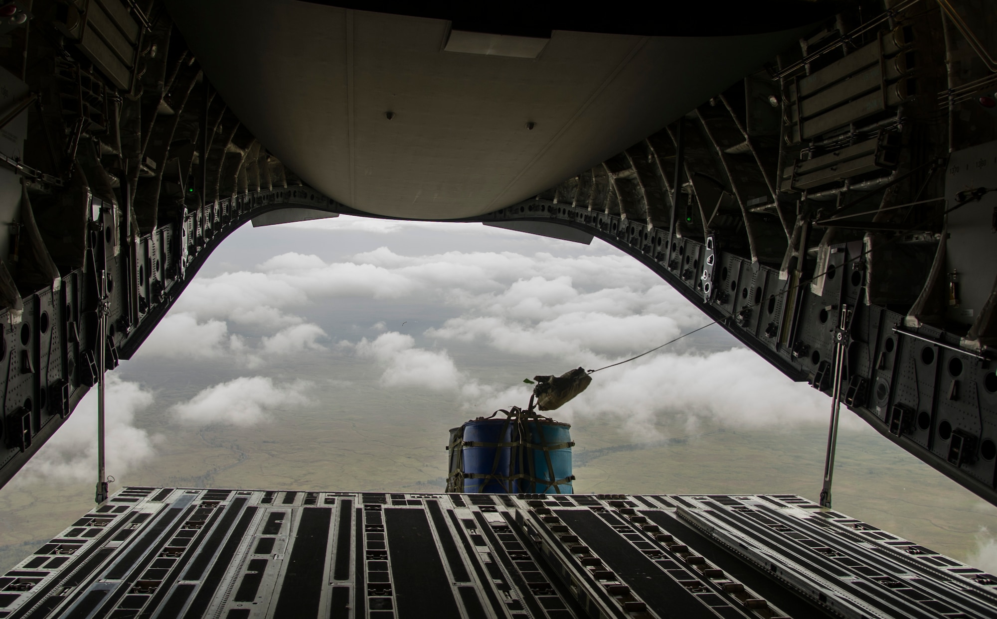 A pallet of water barrels is released from a C-17 Globemaster III during an airdrop mission over Big Island, Hawaii, Jan. 25, 2018. Airdrop missions are part of the routine training for aircrew and logistics personnel. (U.S. Air Force photo by Tech. Sgt. Heather Redman)