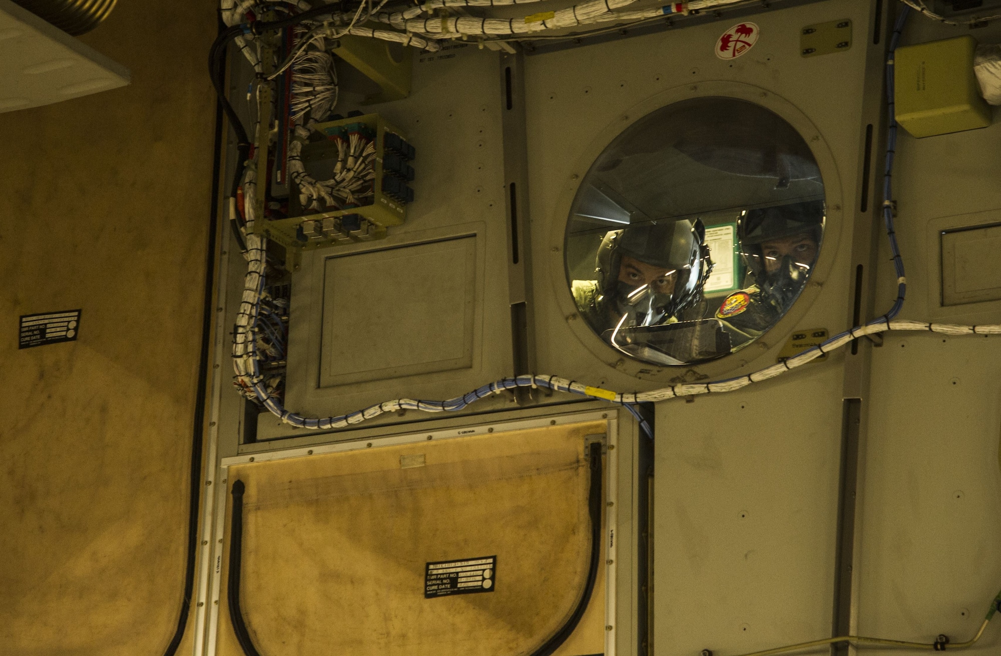 Aircrew members watch the airdrop from the cockpit window during an airdrop mission over Big Island, Hawaii, Jan. 25, 2018. Airdrop missions are part of the routine training for aircrew and logistics personnel. (U.S. Air Force photo by Tech. Sgt. Heather Redman)