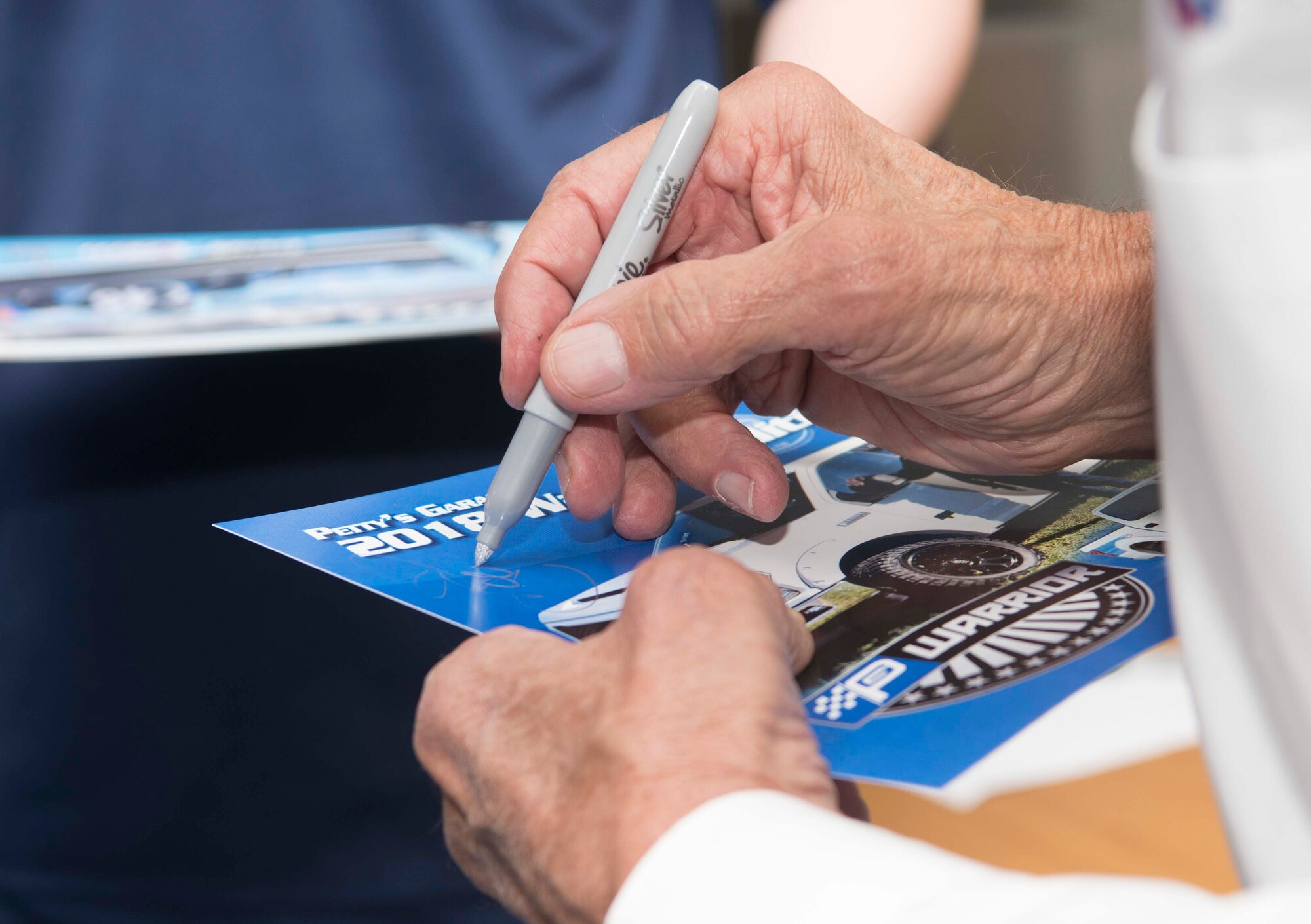 Richard Petty, Nascar legend, signs his autograph for a member of team Ramstein on Ramstein Air Base, Germany, Jan. 27, 2018. United States Air Force Recruiting Europe invited Petty to answer questions about his career for young men and women in the process of joining the Air Force, in part because the Air Force Recruiting Service sponsors Petty and Richard Petty Motor Sports, which displays the Air Force symbol on Nascar racecar number 43. (U.S. Air Force photo by Senior Airman Elizabeth Baker)