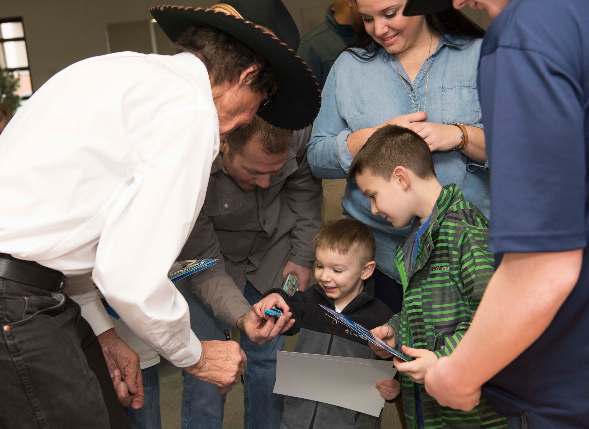 A child receives a toy car which Richard Petty, Nascar legend, signed on Ramstein Air Base, Germany, Jan. 27, 2018. Petty signed memorabilia, took pictures with new Air Force recruits and their families, and participated in a question and answer session in part because the Air Force Recruiting Service sponsors Petty and Richard Petty Motor Sports, which displays the Air Force symbol on car Nascar racecar number 43. (U.S. Air Force photo by Senior Airman Elizabeth Baker)