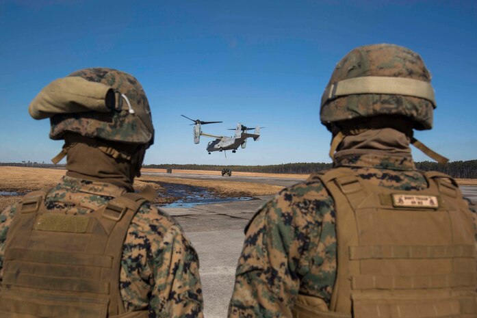 Marines with Landing Support Company, 2nd Transportation Support Battalion, 2nd Marine Logistics Group watch an MV-22 as it prepares to lift and transport a 400 gallon M-149 water tank trailer during sling load operations at Camp Lejeune, N.C., Jan. 25, 2018. The Marines conducted sling load operations to improve their proficiency with loading equipment onto aircraft for transportation. (U.S. Marine Corps photo by Sgt. Chris Garcia)