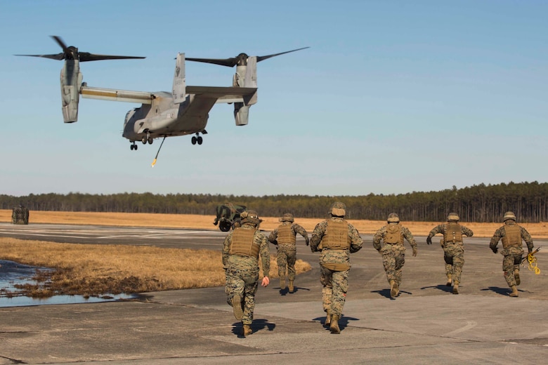 Marines with Landing Support Company, 2nd Transportation Support Battalion, 2nd Marine Logistics Group rush towards a 400 gallon M-149 water tank trailer to prepare it for transportation during sling load operations at Camp Lejeune, N.C., Jan. 25, 2018. The Marines conducted sling load operations to improve their proficiency with loading equipment onto aircraft for transportation. (U.S. Marine Corps photo by Sgt. Chris Garcia)
