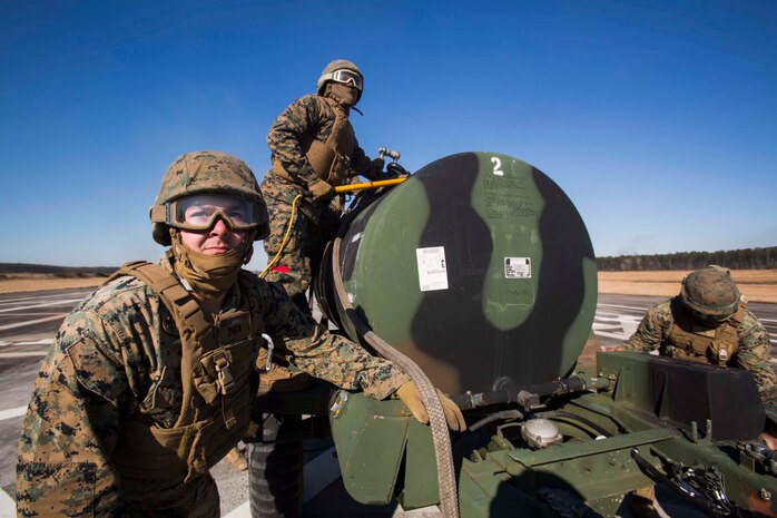 Marines with Landing Support Company, 2nd Transportation Support Battalion, 2nd Marine Logistics Group brace themselves for the high winds produced by a MV-22 osprey and prepare to attach a 400 gallon M-149 water tank trailer to the aircraft during sling load operations at Camp Lejeune, N.C., Jan. 25, 2018. The Marines conducted sling load operations to improve their proficiency with loading equipment onto aircraft for transportation. (U.S. Marine Corps photo by Sgt. Chris Garcia)