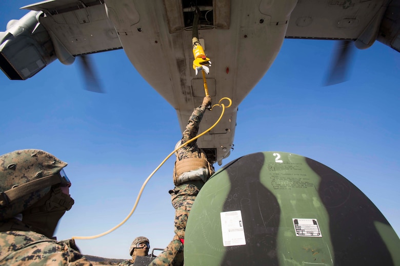 Marines with Landing Support Company, 2nd Transportation Support Battalion, 2nd Marine Logistics Group prepare to attach a 400 gallon M-149 water tank trailer to an MV-22 osprey during sling load operations at Camp Lejeune, N.C., Jan. 25, 2018. The Marines conducted sling load operations to improve their proficiency with loading equipment onto aircraft for transportation. (U.S. Marine Corps photo by Sgt. Chris Garcia)