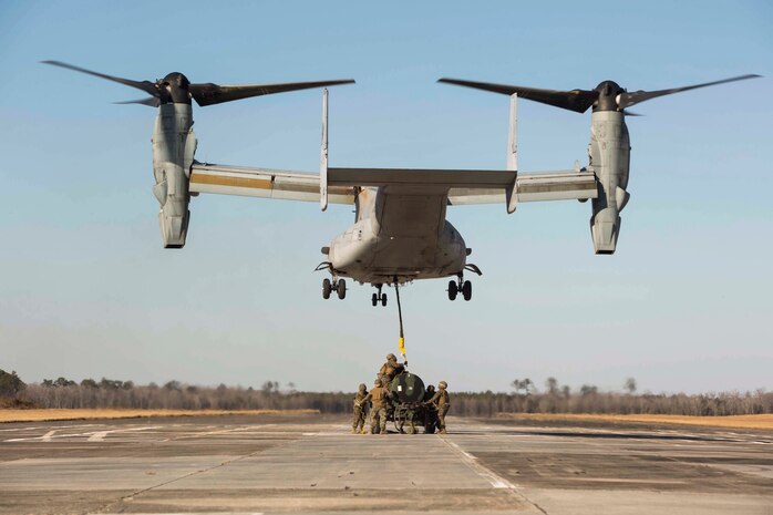 Marines with Landing Support Company, 2nd Transportation Support Battalion, 2nd Marine Logistics Group attach a 400 gallon M-149 water tank trailer to an MV-22 osprey during sling load operations at Camp Lejeune, N.C., Jan. 25, 2018. The Marines conducted sling load operations to improve their proficiency with loading equipment onto aircraft for transportation. (U.S. Marine Corps photo by Sgt. Chris Garcia)
