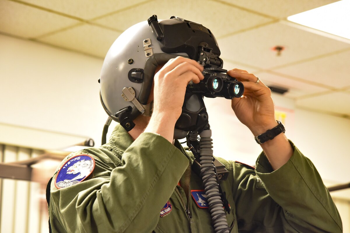 Maj. Casey Minor, 114th FW pilot, tries on the digital eye piece add-on that increases F-16 pilots night flying capabilities at March Air Reserve Base, CA, Jan. 17.