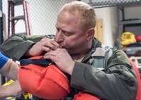 Lt. Col. Clinton Mintz, 71st Rescue Squadron HC-130J Combat King II pilot, inflates a floatation device, Jan. 19, 2018, at Moody Air Force Base, Ga. Aircrew members participated in an underwater survival course to prepare themselves for a situation in which their aircraft were to crash in the water. (U.S. Air Force photo by Airman Eugene Oliver)