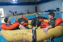 Aircrew members sit in a water raft, Jan. 25, 2018, at Moody Air Force Base, Ga. Aircrew members participated in an underwater survival course to prepare themselves for a situation in which their aircraft were to crash in the water. (U.S. Air Force photo by Airman Eugene Oliver)
