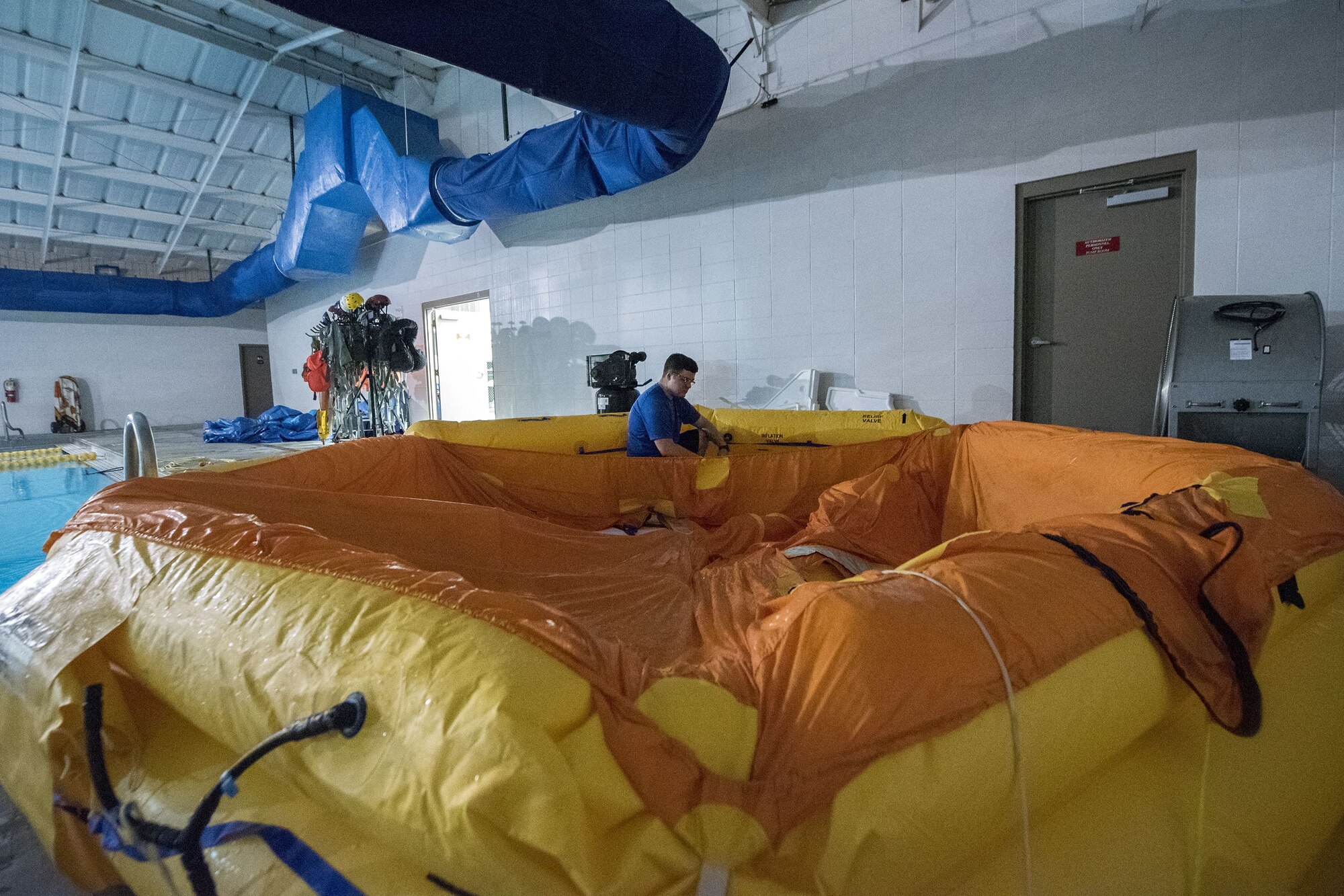 Staff Sgt. Andrew McIntosh, 347th Operations Support Squadron loadmaster, inflates a water raft, Jan. 25, 2018, at Moody Air Force Base, Ga. Aircrew members participated in an underwater survival course to prepare themselves for a situation in which their aircraft were to crash in the water. (U.S. Air Force photo by Airman Eugene Oliver)