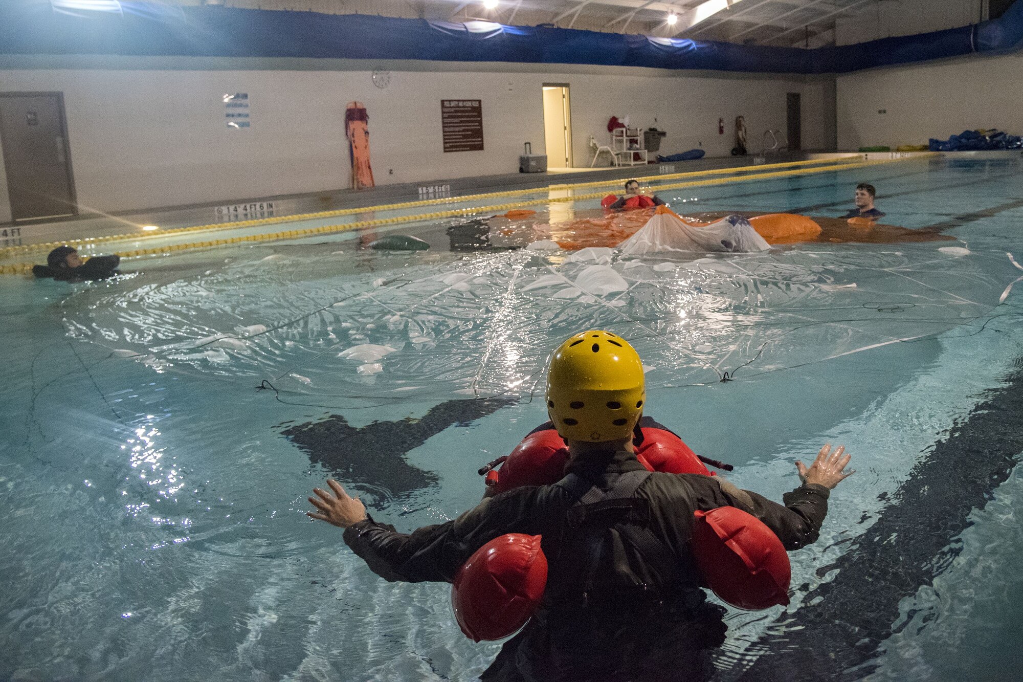 Aircrew members float in a pool surrounding a parachute, Jan. 25, 2018, at Moody Air Force Base, Ga. Aircrew members participated in an underwater survival course to prepare themselves for a situation in which their aircraft were to crash in the water. (U.S. Air Force photo by Airman Eugene Oliver)