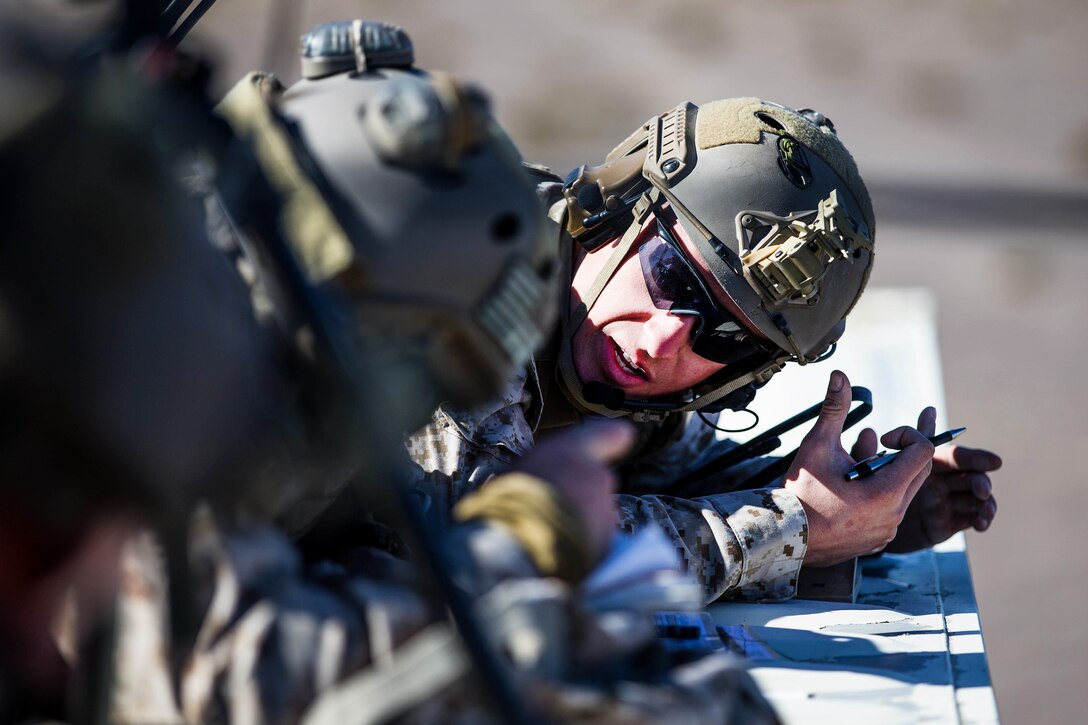 A Marine explains how to call in a medevac request to team members during Integrated Training Exercise 2-18 at Marine Corps Air Ground Combat Center, Twentynine Palms, Calif.
