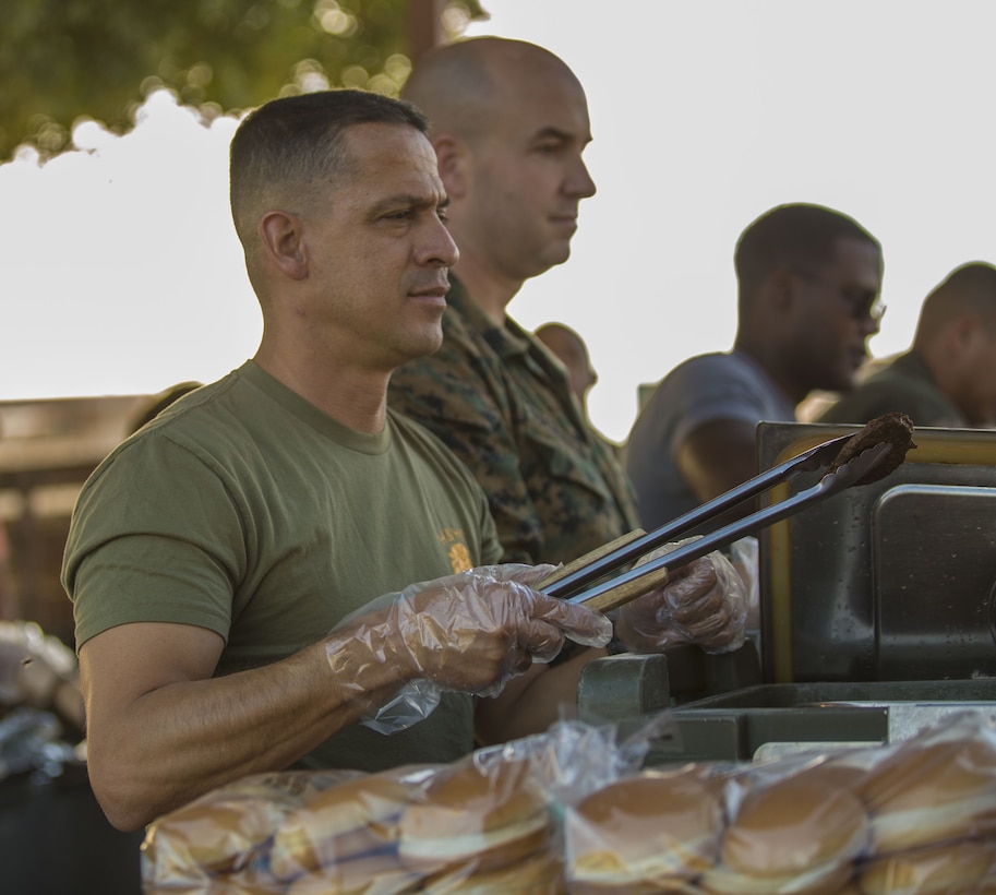 U.S. Marine Corps Sgt. Maj. Fabian Casillas, the sergeant major of Headquarters & Headquarters Squadron (H&HS) on Marine Corps Air Station Yuma, Ariz., serves food to his Marines during the H&HS Barracks Bash at Ramada Field Jan. 18, 2018. H&HS leadership and the station Single Marine Program coordinated the event to boost morale through fun, friendly competition. (U.S. Marine Corps photo taken by Lance Cpl. Sabrina Candiaflores)