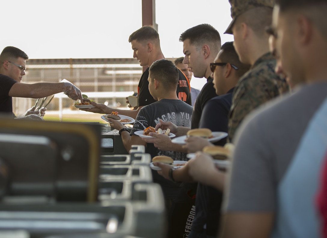 U.S. Marines assigned to Headquarters & Headquarters Squadron (H&HS) on Marine Corps Air Station Yuma, Ariz., receive their food during the H&HS Barracks Bash at Ramada Field Jan. 18, 2018. H&HS leadership and the station Single Marine Program coordinated the event to boost morale through fun, friendly competition. (U.S. Marine Corps photo taken by Lance Cpl. Sabrina Candiaflores)