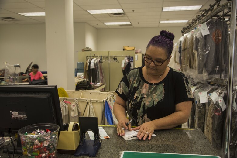 Nica Saucedo, the dry-cleaner’s manager, writes down a customer’s contact information, to attach to the garments, at the dry-cleaners on Marine Corps Air Station Yuma, Ariz., Jan. 10, 2017. The station dry-cleaners is a service provided by the Marine Corps Exchange (MCX) to Marines and civilians, which provides them the opportunity to get their garments cleaned, pressed, fitted, altered or a combination of services if needed. (U.S. Marine Corps photo taken by Cpl. Isaac Martinez)