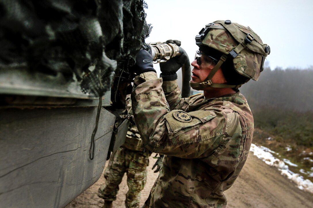 Army Sgt. Matthew Ross fuels a reconnaissance vehicle.