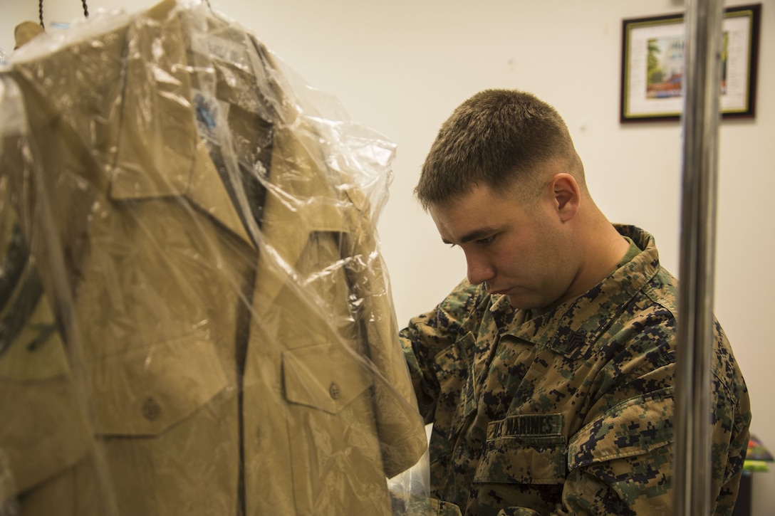 A U.S. Marine stationed on Marine Corps Air Station Yuma, Ariz. looks at his altered uniforms at the station’s dry-cleaners Jan. 10, 2017. The station dry-cleaners is a service provided by the Marine Corps Exchange (MCX) to Marines and civilians, which provides them the opportunity to get their garments cleaned, pressed, fitted, altered or a combination of services if needed. (U.S. Marine Corps photo taken by Cpl. Isaac Martinez)