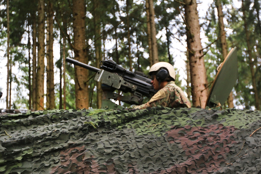A soldier scans his sector while providing security from the turret of his M992 fire support vehicle.