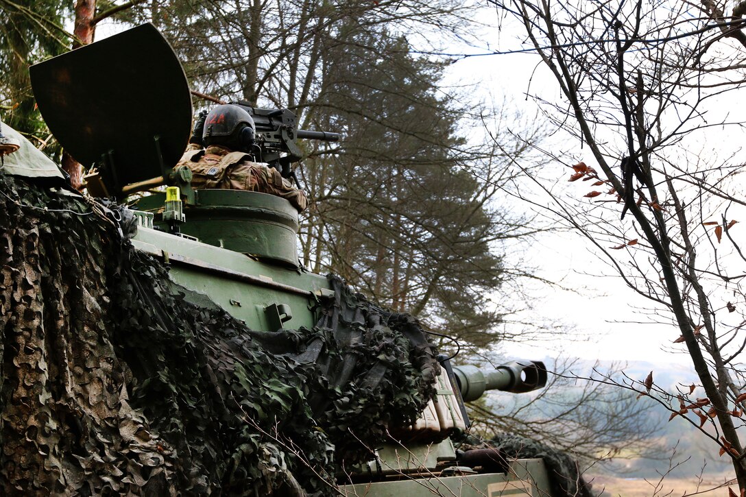 A soldier provides security from the turret of his M109A Paladin self-propelled howitzer while convoying to a firing position.