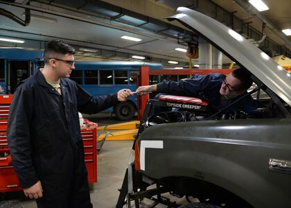 Airman 1st Class John Figueiredo hands a socket wrench to Airman 1st Class Jeremiah Wilson, both Airmen are mission general vehicle equipment maintenance apprentices with the 673d Logistics Readiness Squadron Vehicle Maintenance, General Purpose shop, Jan. 25, 2018, at Joint Base Elmendorf-Richardson, Alaska. The General Purpose shop repairs and services bobtails, busses, forklifts, Humvees and Wollard MB-4’s.