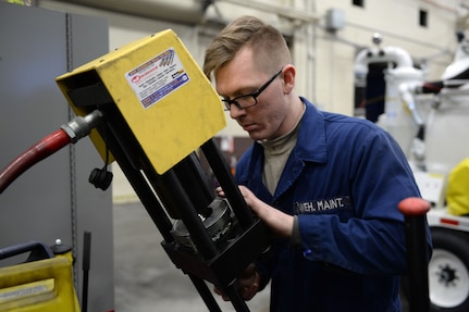 Airman Craig Boudreau, mission general vehicle equipment maintenance apprentice with the 673d Logistics Readiness Squadron Vehicle Maintenance, Flightline Maintenance shop, uses a compressor to put thread casing on hosing, Jan. 25, 2018, at Joint Base Elmendorf-Richardson, Alaska. Flightline maintenance repairs and services all of the Global deicer trucks, Caterpillar 50K forklifts, 60K aircraft cargo loader/transporters and Grove MB-2 aircraft tug/pushback tractors used for flightline operations.