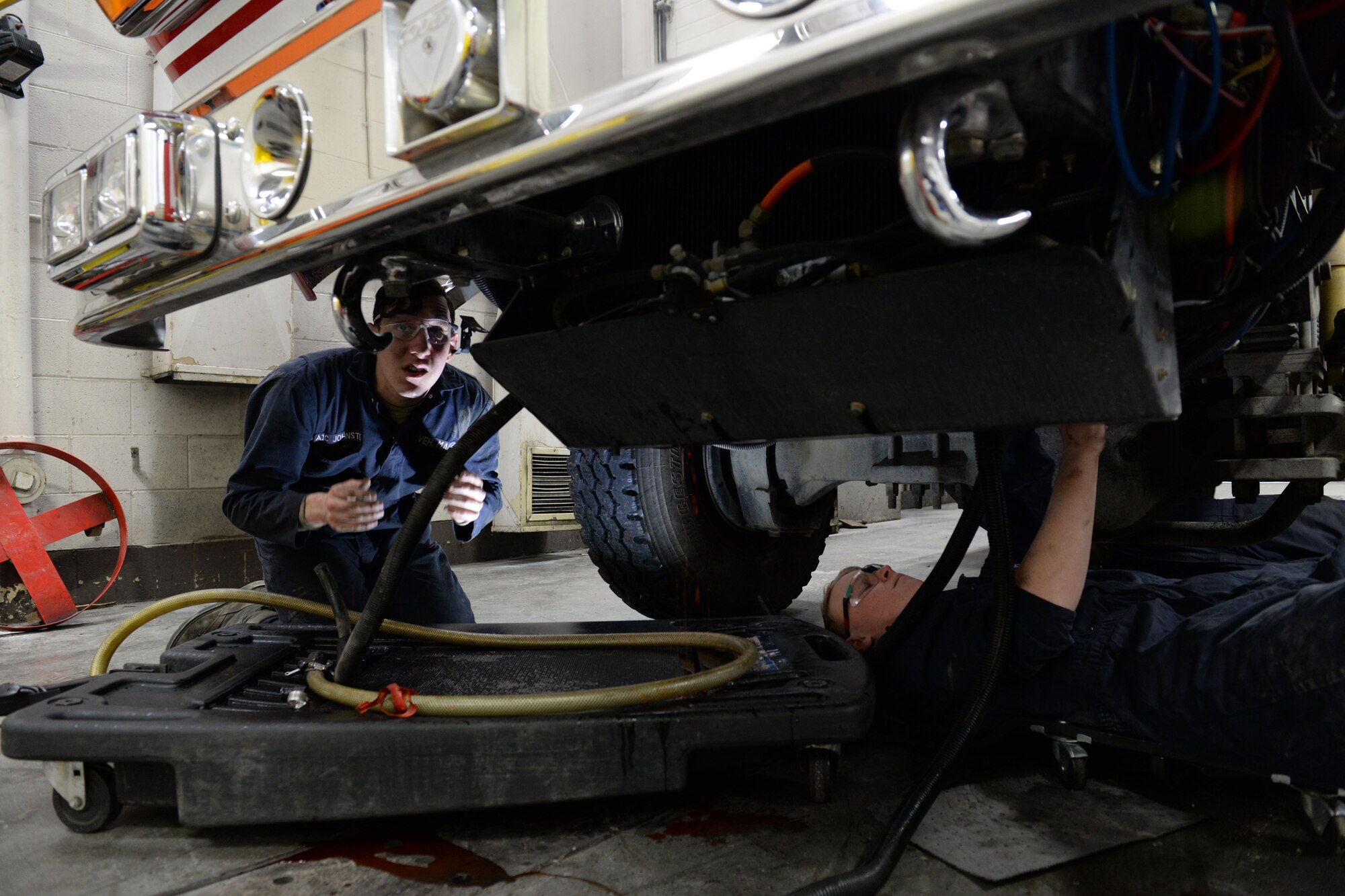 Airman 1st Class Shane Ousdahl (right) and Airman 1st Class Nicholas Johnston, fire truck maintenance apprentices with the 673d Logistics Readiness Squadron Vehicle Maintenance, Fire Truck Maintenance shop, changes coolant hoses, Jan. 25, 2018, at Joint Base Elmendorf-Richardson, Alaska. The Fire Truck Maintenance shop repairs and services all fire trucks at JBER.