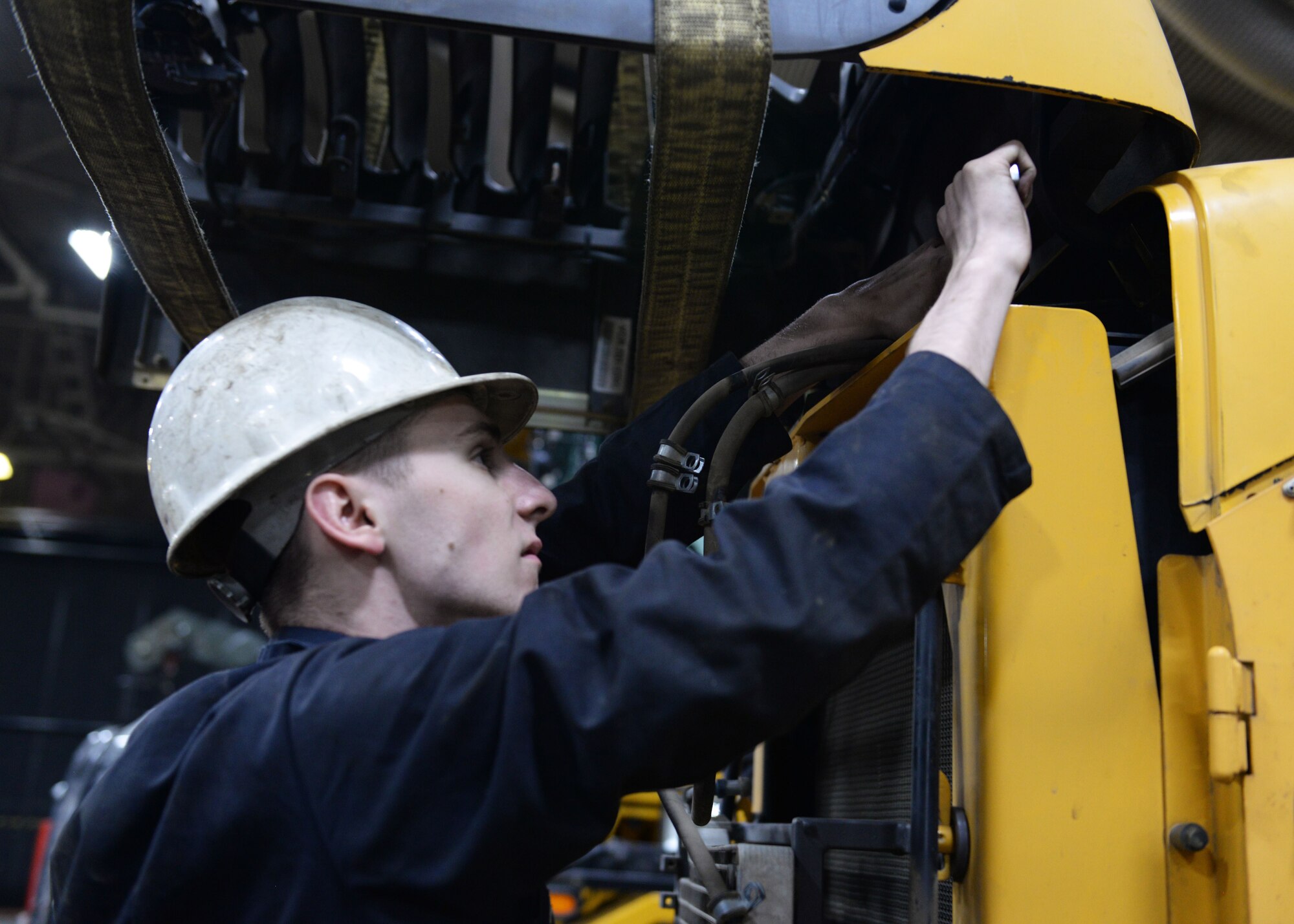 Senior Airman Samuel Reilly, a mission general vehicle equipment maintenance journeyman, with the 673d Logistics Readiness Squadron Vehicle Maintenance, Heavy Equipment shop, tightens a bolt on a cover panel attached to a L60F loader, Jan. 25, 2018, at Joint Base Elmendorf-Richardson, Alaska. The Heavy Equipment shop repairs and services all snow-removal and road equipment at JBER.