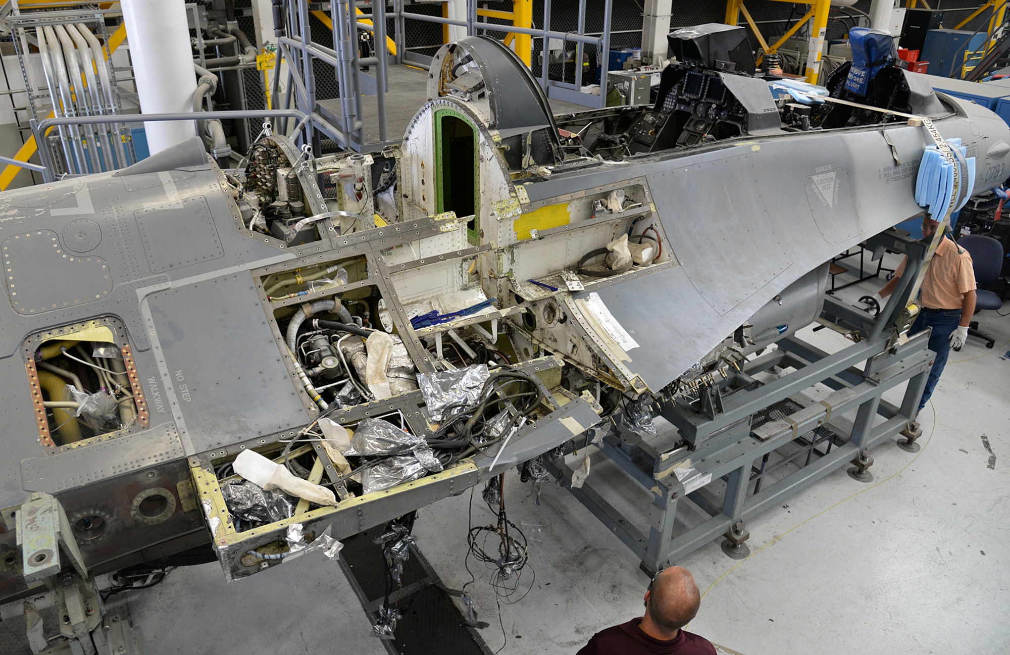 J. C. Robinson (far right), 576th Aircraft Maintenance Squadron, turns the wheel on a special jig to separate the fuselage on F-16D, 90-0783, on Aug. 03, 2017, at Hill Air Force Base, Utah. The aircraft was involved in a bird strike and during its post-flight inspection the crew chief discovered the 243 bulkhead had a large crack. It was determined that the only possible way of repairing the airframe was to separate it into two sections. (U.S. Air Force photo by Alex R. Lloyd)
