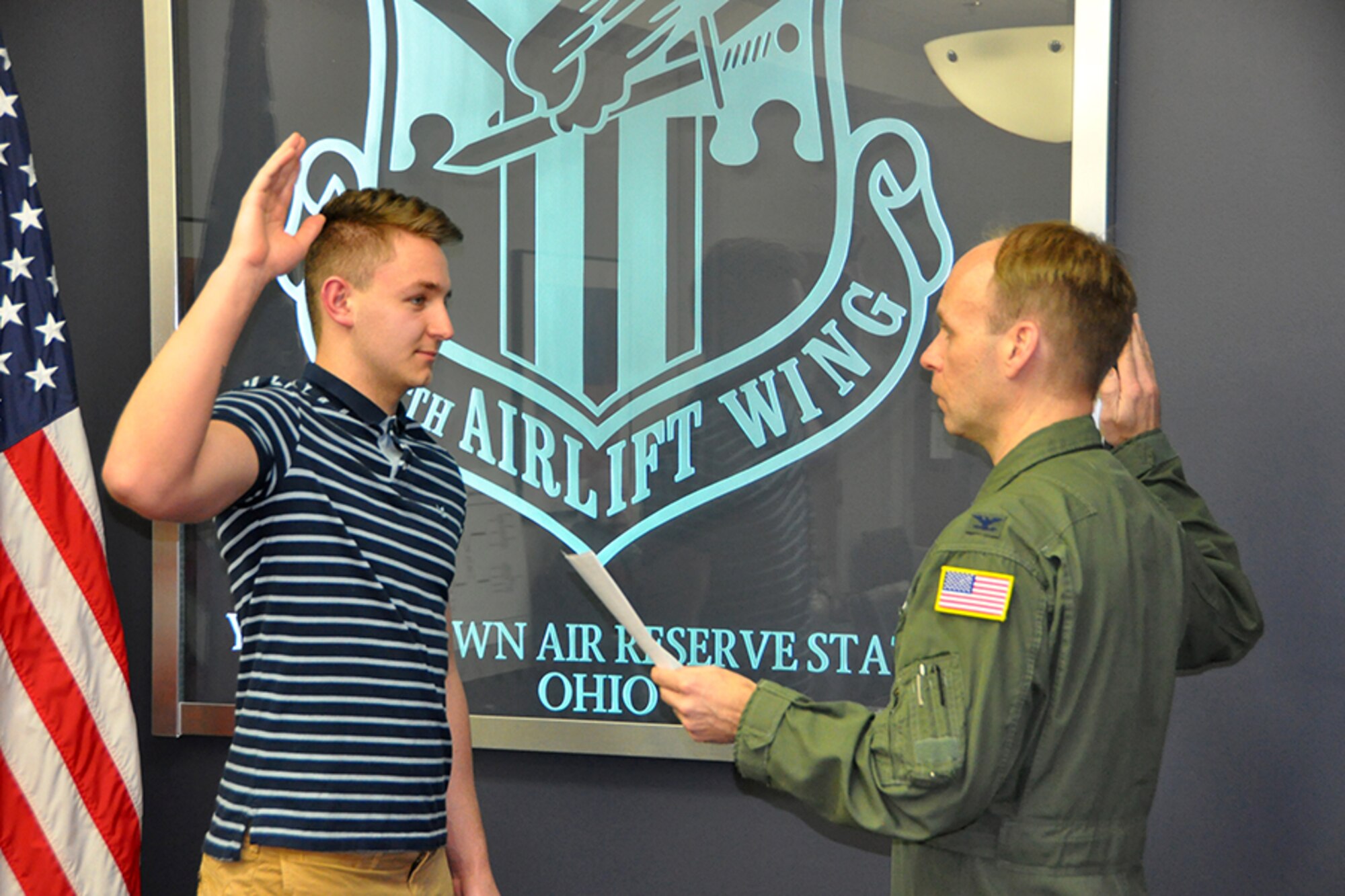 Robert Adler, a new recruit to the 910th Security Forces Squadron, holds an Air Force Reserve sign after taking the oath of enlistment to become a Reserve Citizen Airmen here, Jan. 29, 2018.